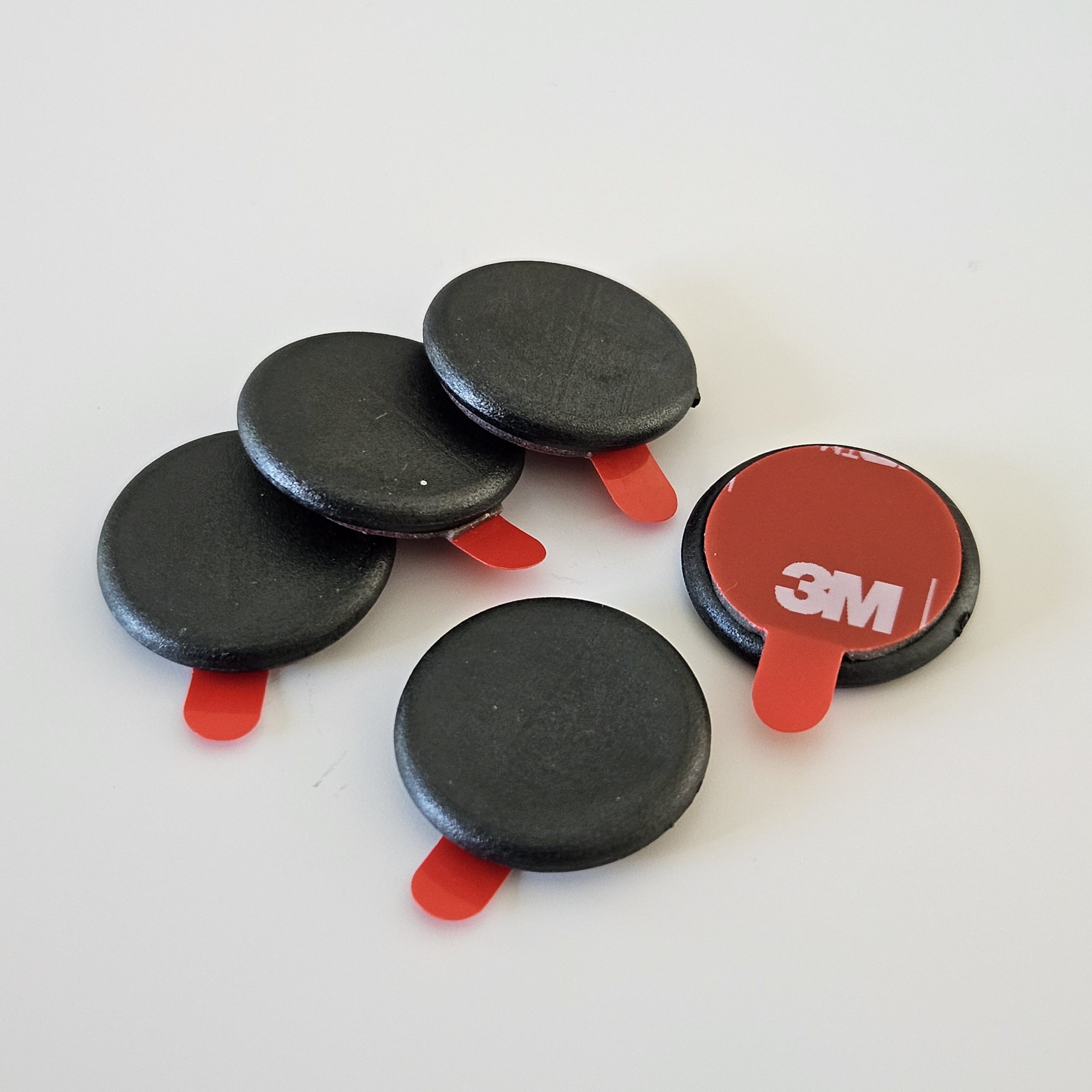 A group of NFC hard tags with 3M VHB adhesive and release liner with easy-pull tab.